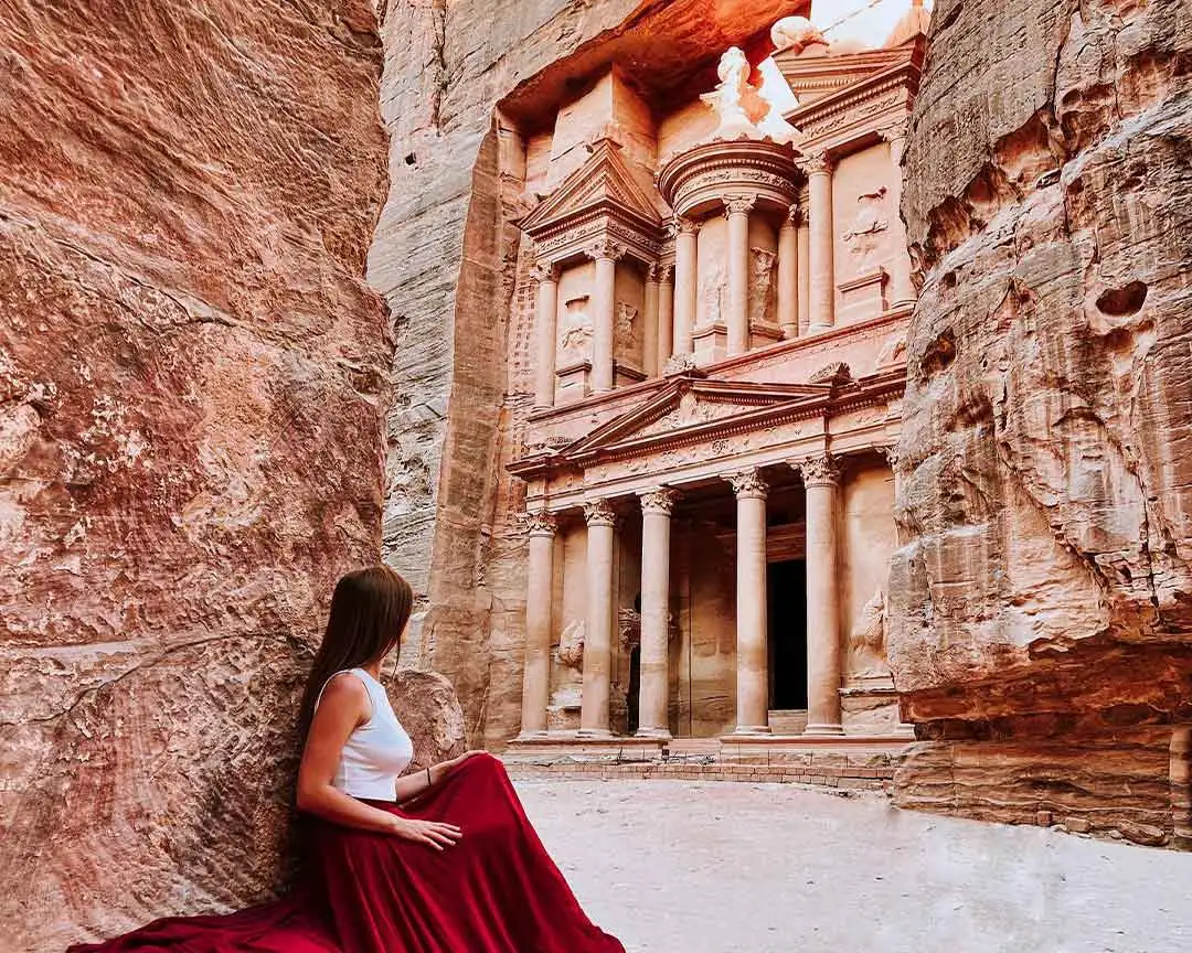 A traveller in the Siq looking towards the Treasury at Petra, Jordan