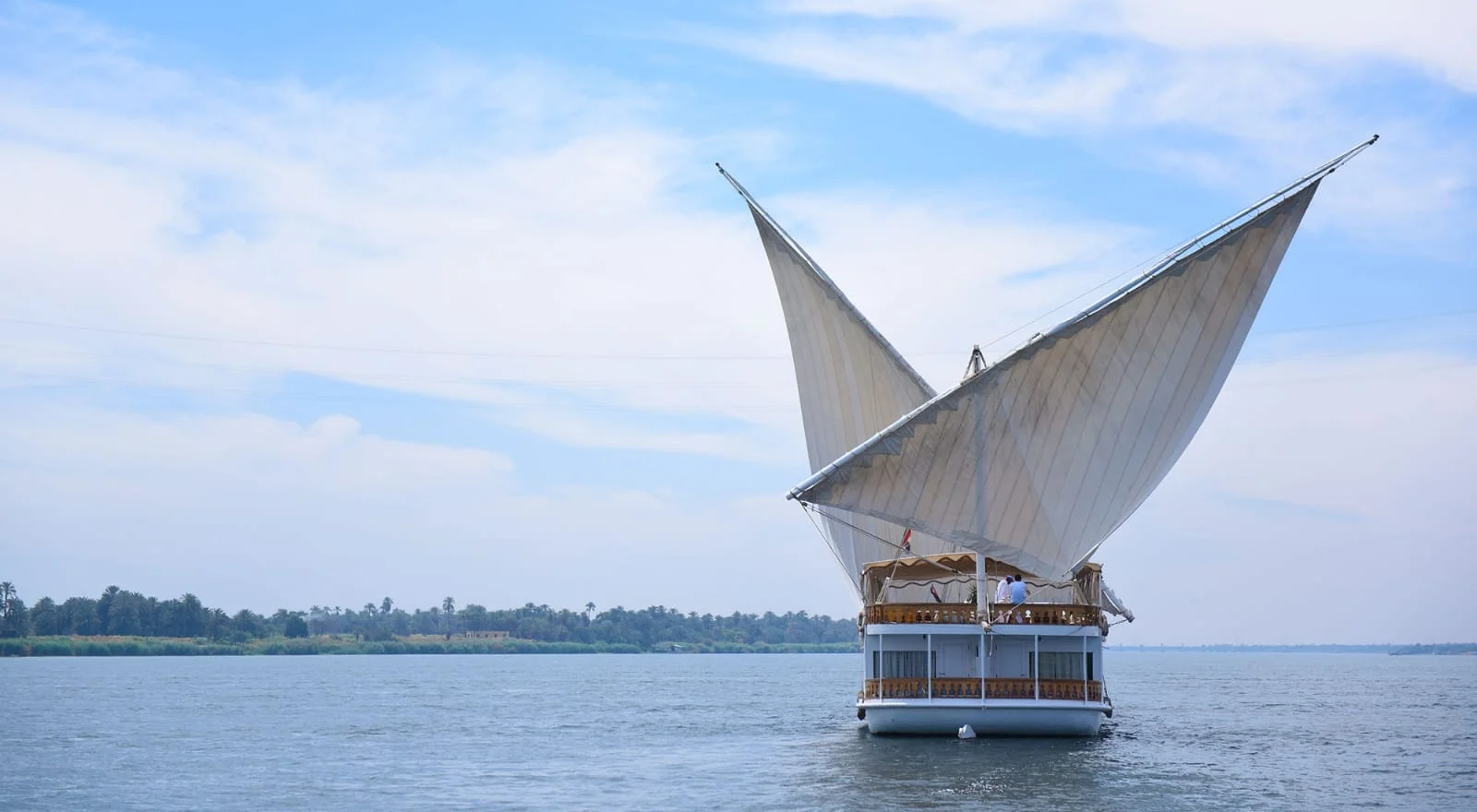 A traditional dahabiya with two white sails on the Nile