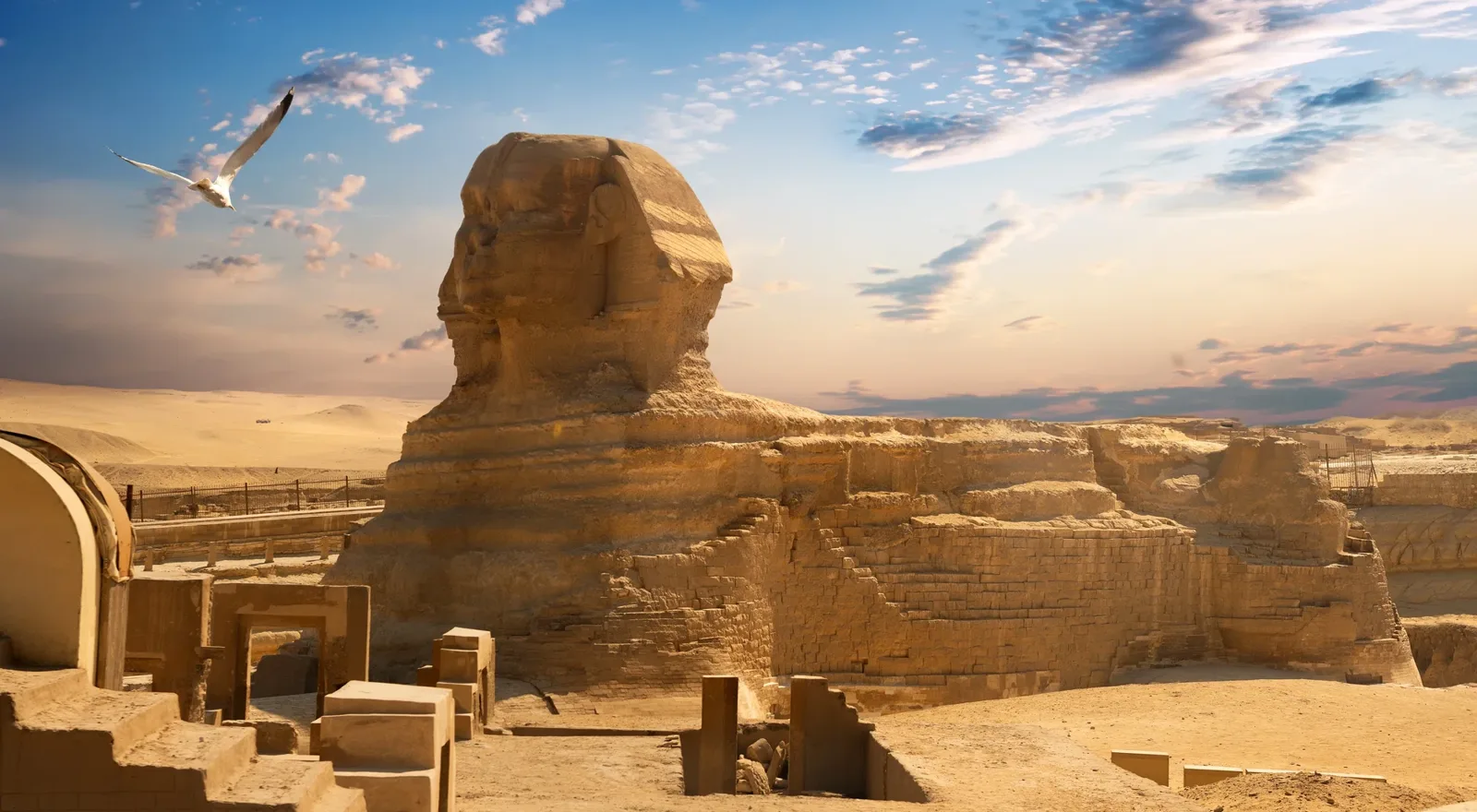 La Esfinge de Guiza al atardecer, con restos de templos de piedra en primer plano