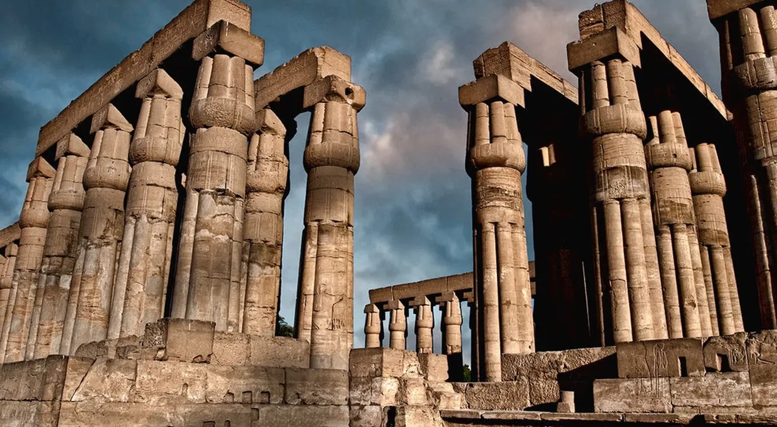 Columnas del templo de Luxor con capiteles en forma de papiro bajo un cielo con nubes
