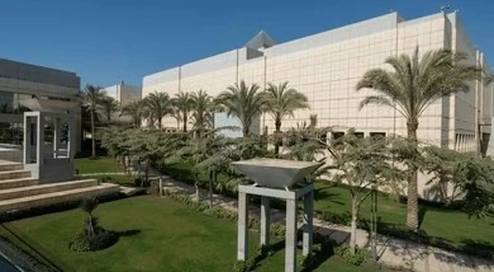 Edificio del Museo Nacional de la Civilización Egipcia, rodeado de jardines y palmeras