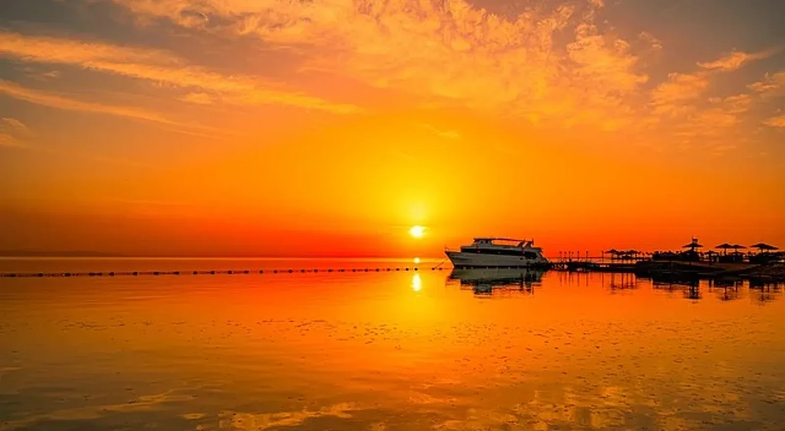 Puesta de sol sobre el mar Rojo en Hurghada, con barcos en el horizonte