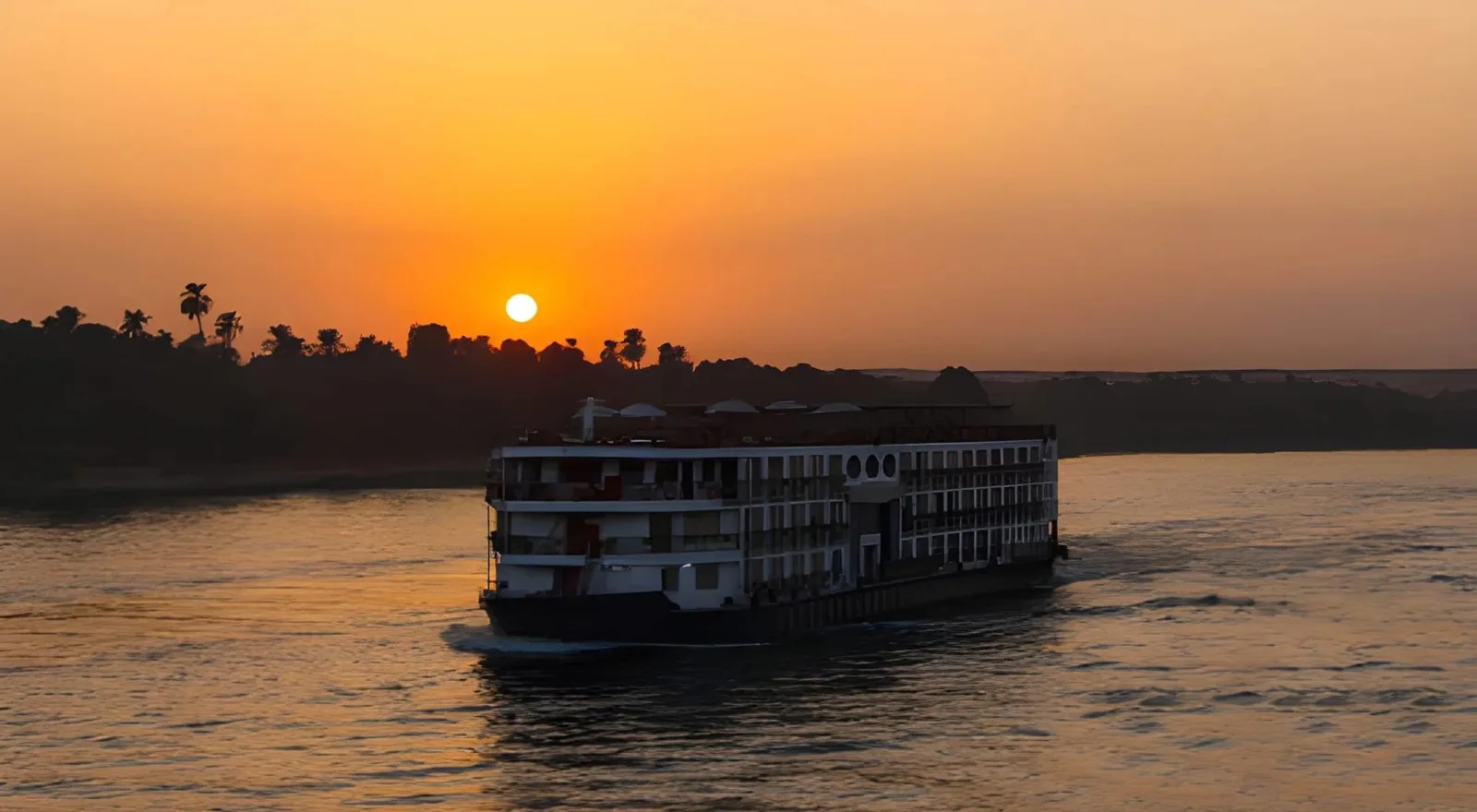 A Nile cruise ship sailing at sunset