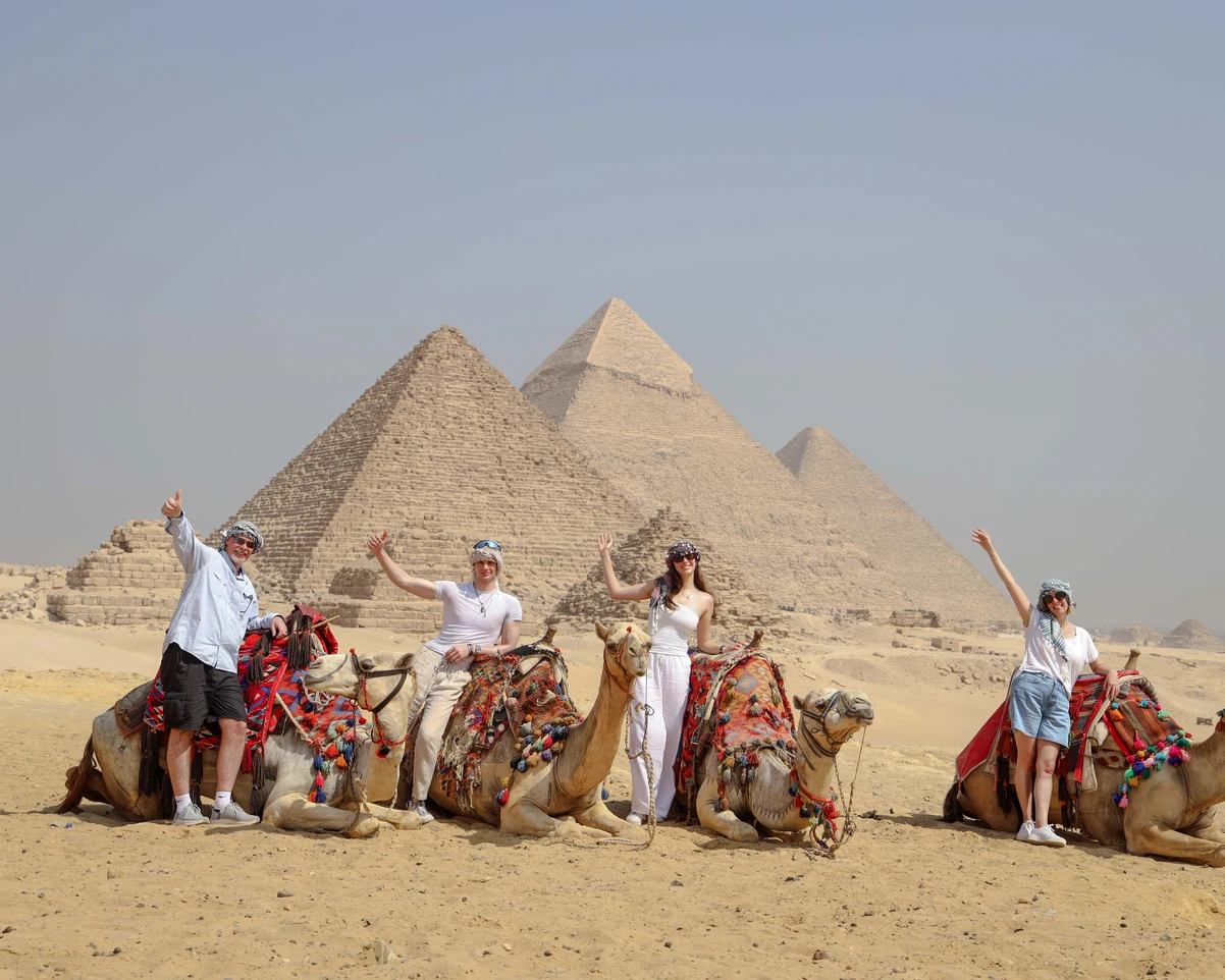A family taking photos in front of the pyramids