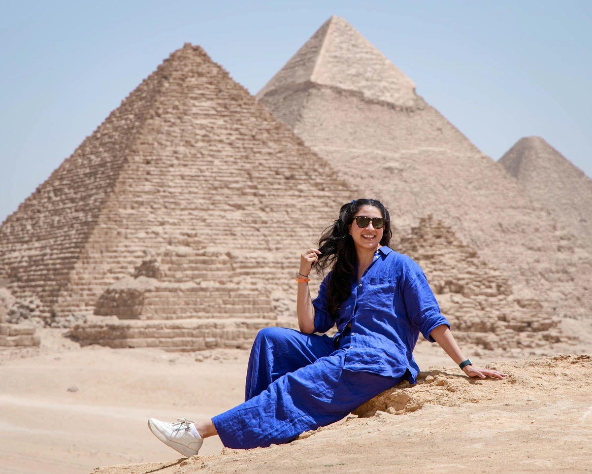 A tourist taking photos in front of the pyramids