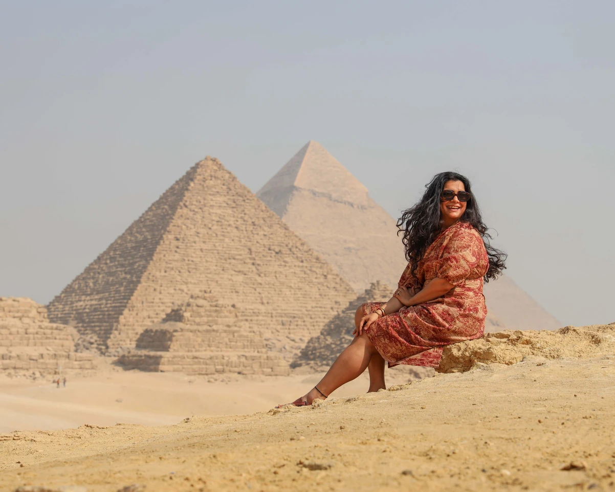 A tourist taking photos in front of the pyramids