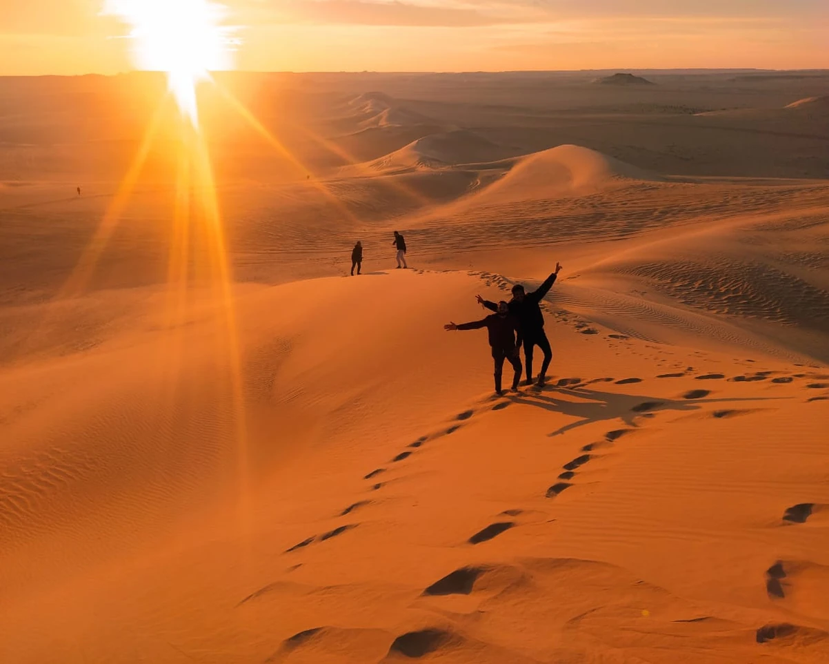 Tourists taking photos in the Siwa Desert during sunset