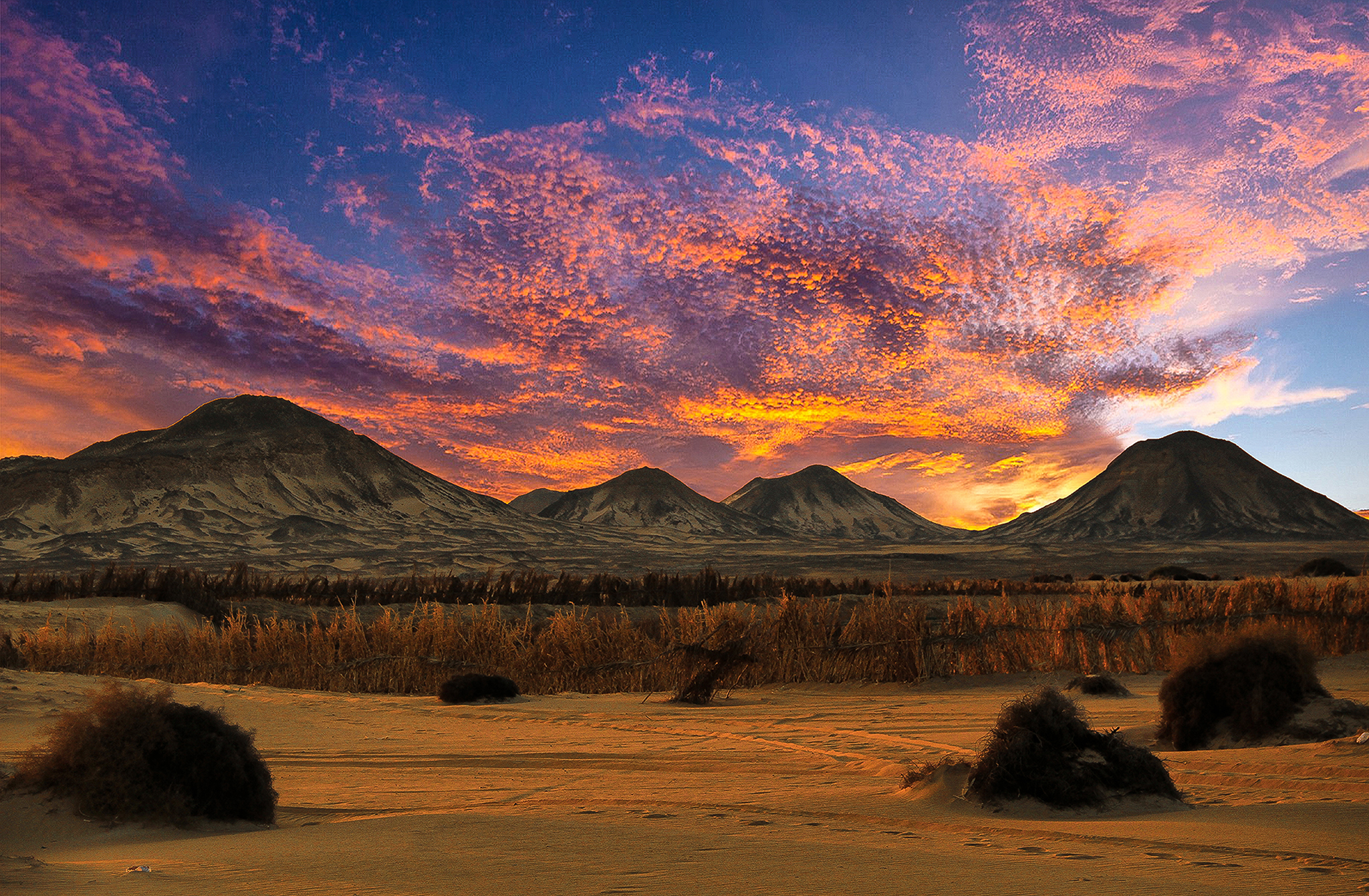 The Black Desert peaks under a sunset sky in Bahariya Oasis