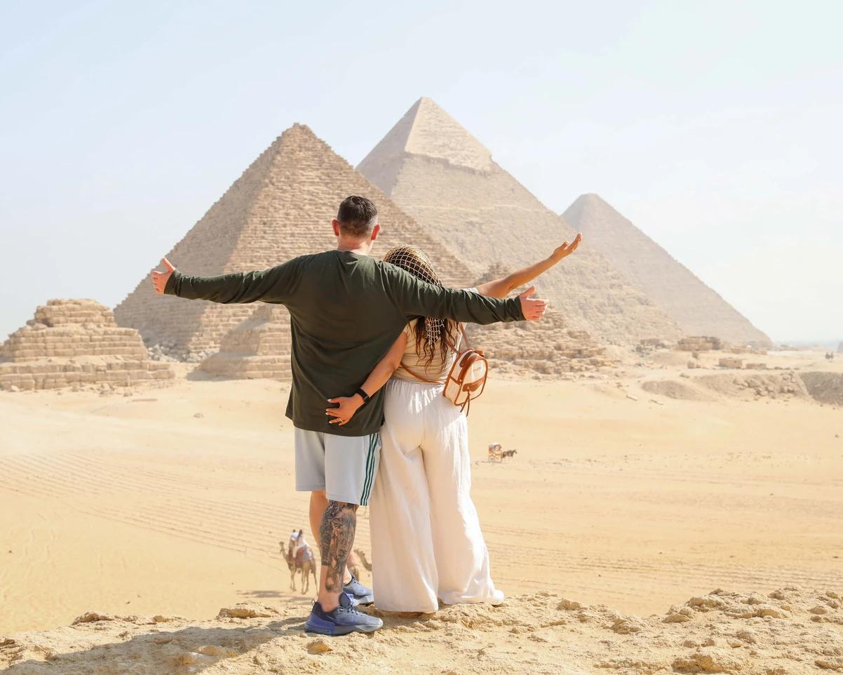 American asian girl on the camel next to the pyramids in Giza with iEgypt tours